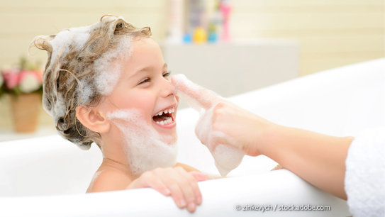 Junge mit Schaumkrone sitzt in der Badewanne