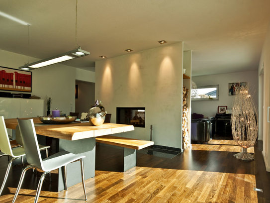 Haus Götze beeindruckt mit der Wand als Raumtrenner mit einem eingebauten Kamin und einer Holzablage. (Foto: BAUMEISTER-HAUS)