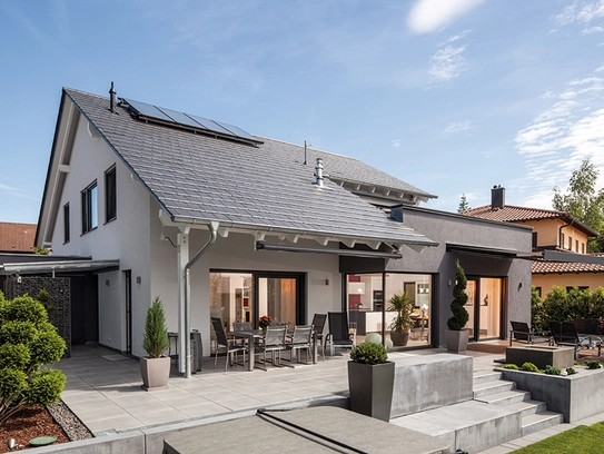 BAUMEISTER-HAUS Uthoff – Auf der Gartenseite sorgen große Glasflächen für fließende Übergänge und beziehen die beiden Freisitze ins Wohngeschehen mit ein
