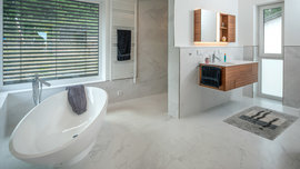 Badezimmer mit Trennwand und freistehender ovaler Badewanne