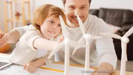 Klimaneutrale Bauen ist ein wichtiges Ziel für die Zukunft. (Foto: © zinkevych / stock.adobe.com) Vater und Sohn mit Miniatur-Windrädern