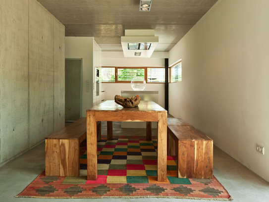 Haus Immel - die perfekte Kombination aus Holz und moderner Betonwand. Der massive Esstisch wird zum Hingucker des Raumes. (Foto: © BAUMEISTER-HAUS)