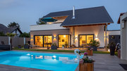 Vergessen das Licht aus zu machen? Kein Problem – das lässt sich wie hier bei Haus Ibach einfach mittels App auf dem Smartphone unterwegs erledigen. (Foto: © BAUMEISTER-HAUS) Beleuchtete Ansicht von Haus Ibach mit Pool