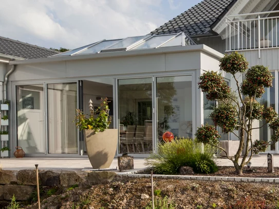 Im Sommer der direkte Zugang zur Terasse, im Winter ein Ort, an dem man Sonne tanken kann, ohne das Haus zu verlassen – der Wintergarten von Haus Günther (Foto: BAUMEISTER-HAUS)