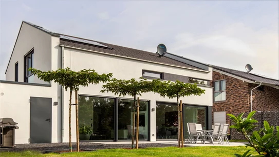 Die Schirmplatane im Garten von Haus Nowak ersetzt den besten Sonnenschirm und spendet natürlichen Schatten. (Foto: BAUMEISTER-HAUS)