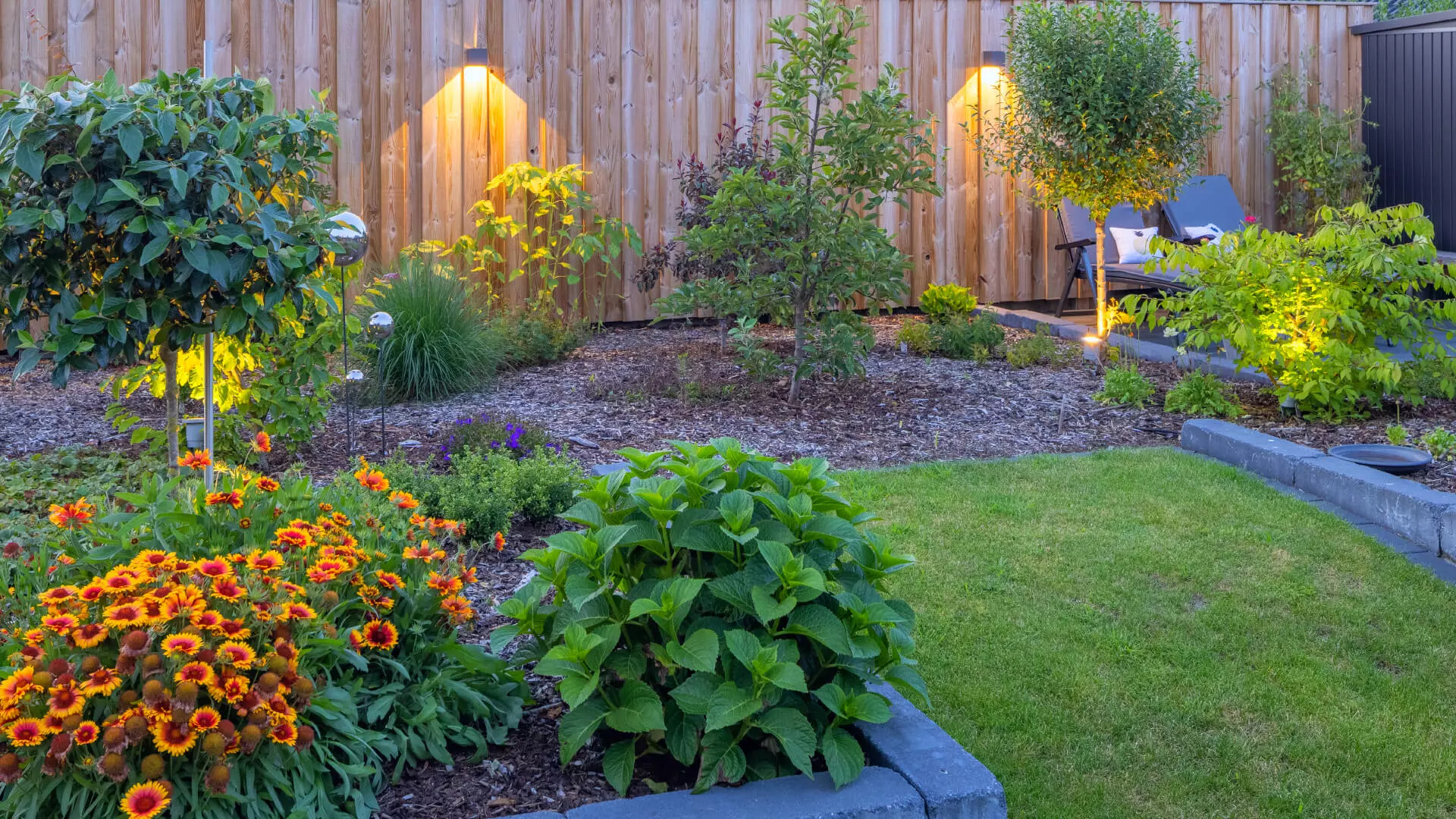 Beleuchteter Holzzaun rund um den Garten