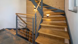 Farbliche Kontraste – wie hier im Haus Thalheim – lassen die Treppe zum Hingucker werden. (Foto: @ BAUMEISTER-HAUS) Treppe aus Holz und Metall