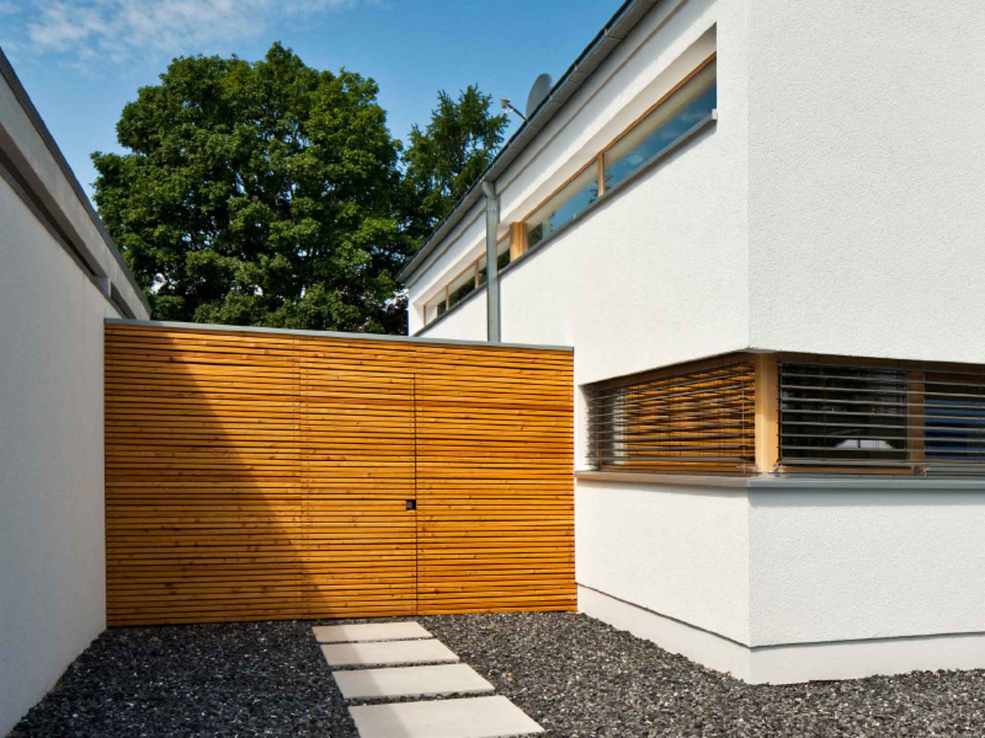 Haus Immel – die spezielle Holzoptik des Tores bildet mit den Holzelementen der Fenster eine harmonische Einheit (Foto: © BAUMEISTER-HAUS)